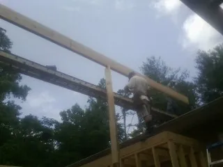 Carpenter setting a ridge beam over a new addition frame — Ice Dam Removal by Roofing Brothers in Salyer